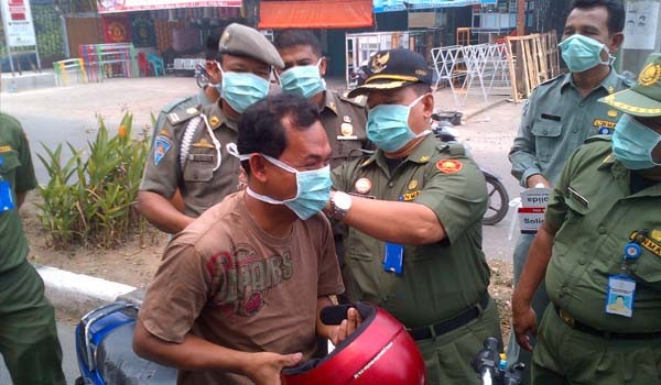 Sekda Merangin, Sibawaihi, saat turun langsung membagikan masker pada warga Merangin didepan Kantor Bupati