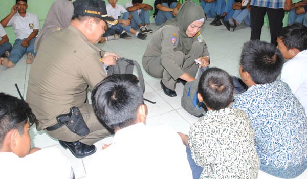 Petugas Satpol PP Kota Jambi saat melakukan pemeriksaan tas siswa, WISMAN WAZIR/JAMBI EKSPRES