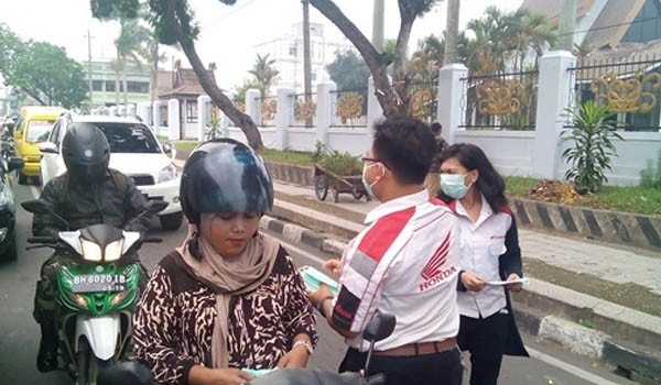 Karyawan/ti Honda membagikan masker kepada pengendara sepeda motor yang sedang melintas