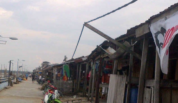 Kabel listrik yang hanya ditopang kayu agar tidak menyentuh seng rumah warga