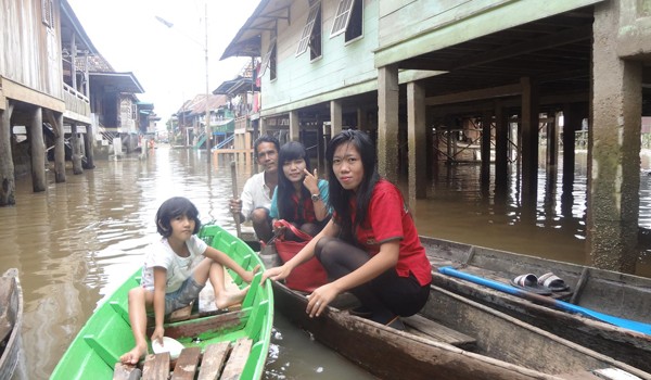 OJEK : Kadir, penyedia jasa Ojek Perahu ketika membawa penumpang untuk mencapai jalan yang tidak terkena banjir.  ALI ALIM/JE
