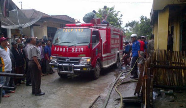 Pemadam kebakaran yang berusaha memadamkan api yang berkobar