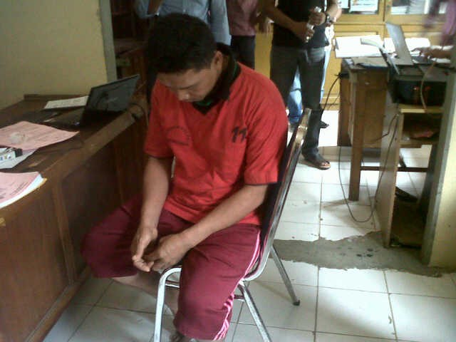 Tersangka pencabulan M saat diamankan di kantor polisi