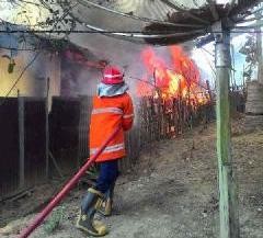 Petugas pemadam kebakaran saat berusaha memadamkan api yang melalap bedeng di Rantau Pandan