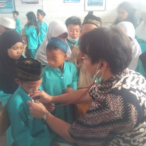 Salah satu petugas memeriksa kesehatan siswa SD di Pulau Pandan
