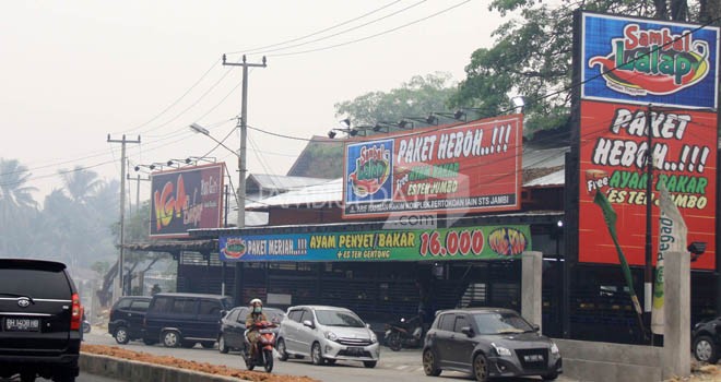 Terlihat beberapa kendaraan pengunjung Rumah Makan Sambal Lalap terparkir menggunakan badan jalan.