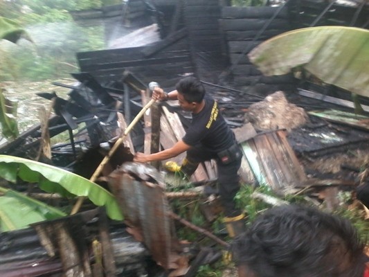 Petugas Damkar saat mengecek puing-puing rumah yang hangus terbakar 