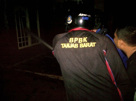 Warga bersama petugas saat memadamkan api