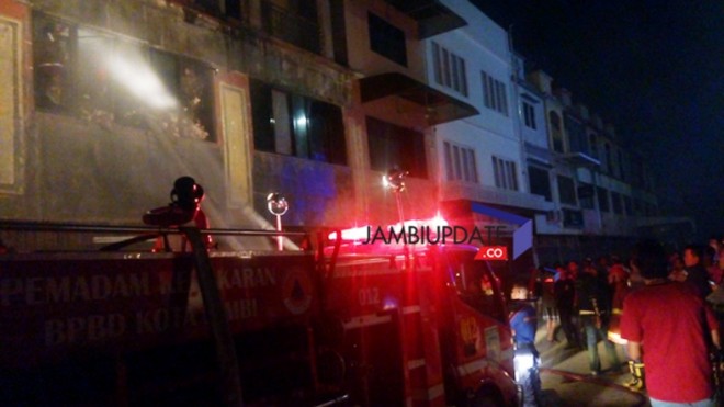 Petugas pemadam kebakaran saat berusaha memadamkan api malam ini di salah satu toko di kawasan WTC Pasar Jambi