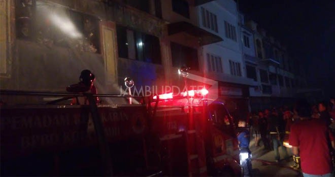 Petugas pemadam kebakaran saat berusaha memadamkan api malam ini di salah satu toko di kawasan WTC Pasar Jambi.