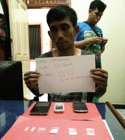 Tersangka Burhan saat diamankan bersama barang bukti di Mapolresta Jambi, Sabtu (27/2).