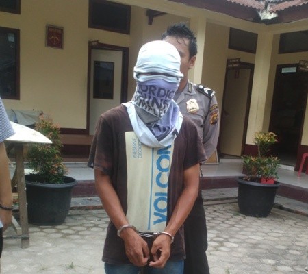 Tersangka Misnadi yang ditahan di Mapolsek Telanaipura.