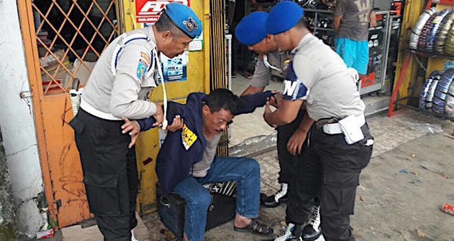 Wakapolsek Kemayoran AKP Jamal Alkitri yang terduduk dalam kondisi mabuk saat dijemput petugas Propam dari Polres Jakarta Timur di Jalan Otista Raya, Senin (8/8) pagi. <i>Foto: WhatsApp Group Pewarta Polda Metro Jaya</i>