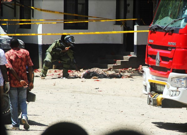 Ahli peledak memeriksa salah satu pelaku yang tewas dalam serangan di kantor pusat polisi di Mombasa, Kenya. Foto: AFP