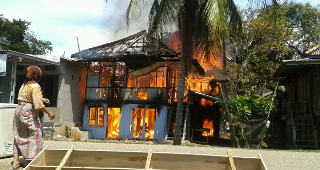Terlihat api yang masih membesar membakar rumah milik warga.