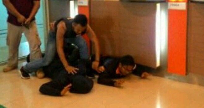 Polisi melumpuhkan 2 orang nasabah yang mencurigakan dan merebahkannya ke lantai.