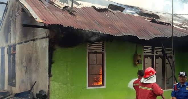 Petugas Pemadam Kebakaran tengah memadamkan Api yang memebakar rumah Agus Siswoto.