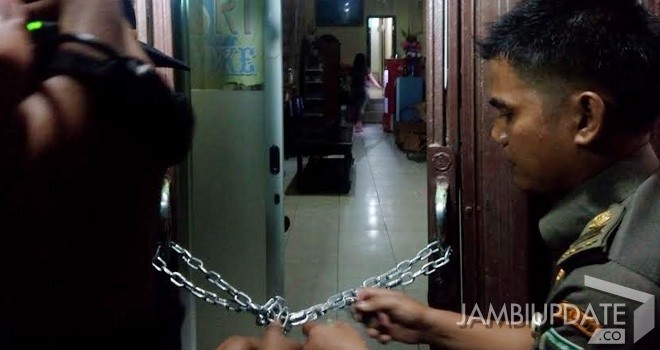 Petugas yang menyegel salah satu tempat hiburan di Kota Jambi.