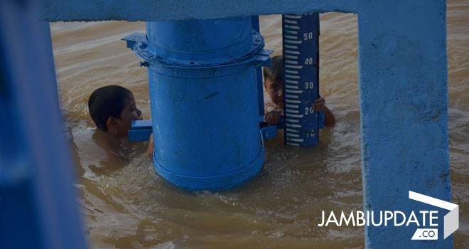 Terlihat dua anak-anak mandi di di Sungai Batanghari  bermain dekat alat pengukur ketinggian debit sungai. Foto : Ridwan/JE