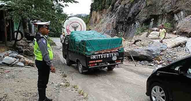 Petugas kepolisian mengatur arus lalu lintas di lokasi longsor di jalur lintas Riau-Sumbar. Foto: riaupos/jpg