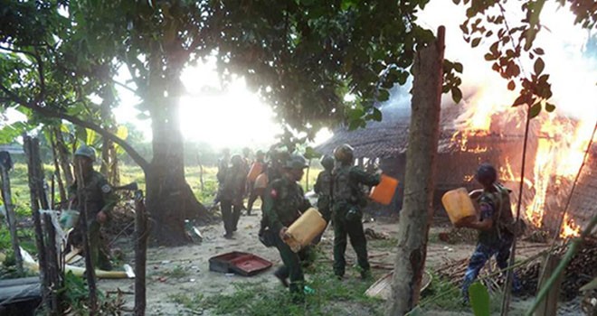 Foto ini dirilis oleh Angkatan Bersenjata Myanmar pada 13 November lalu dengan informasi menyatakan tentara sedang memadamkan api yang membakar rumah warga di Rakhine. Foto: MYANMAR ARMED FORCES/AFP