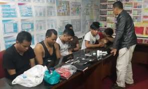 Anggota Polsek Pancoran (berdiri) saat memeriksa para pria yang diduga pelaku pesta seks sesama jenis di Apartemen Kalibata City. Foto: Polda Metro Jaya