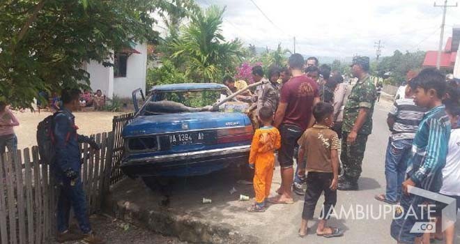 Terlihat mobil sedan menabrak pagar rumah warga.
