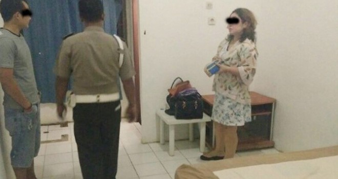 Bripka RJS (kiri, bercelana pendek) dan Yuli yang digerebek di salah satu hotel di Entikong oleh Polsek setempat. Warga Entikong for Rakyat Kalbar.