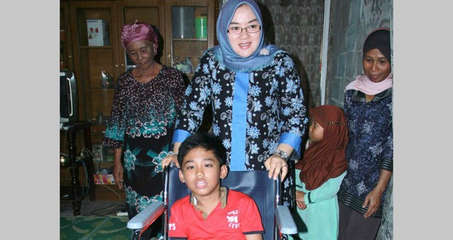Ketua Tim Penggerak PKK Kota Jambi Hj. Yuliana Fasha menyerahkan kursi roda di Kelurahan Kenali Besar Kecamatan Alam Barajo.