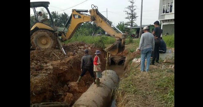Terlihat satu unit excavator melakukan perbaikan saluran drainase di SDN 84 Kelurahan Payo Selincah Kecamatan Paal Merah.