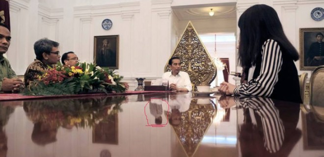 Bayangan misterius memantul di meja rapat Jokowi bersama tim produksi patung lilin. (Facebook/Madame Tussauds)