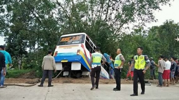 Jajaran Sat Lantas Polres Sambas mengevakuasi bus Nek Aki yang masuk parit di Desa Kartiasa, Minggu (12/3). Foto: SAIRI/Rakyat Kalbar/JPNN.com