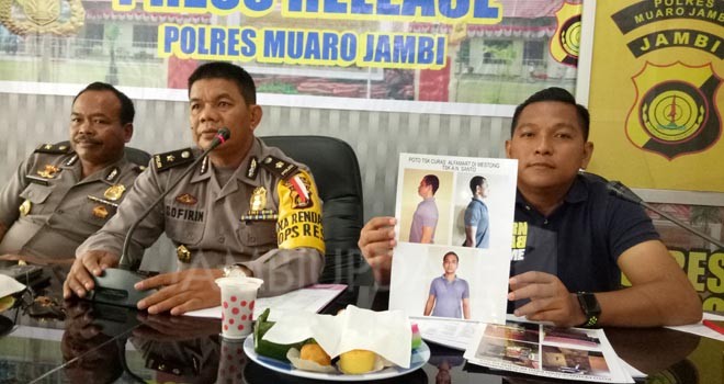 Polisi saat memperlihatkan foto perampok Alfamart Sebapo saat press release di Polres Muaro Jambi.