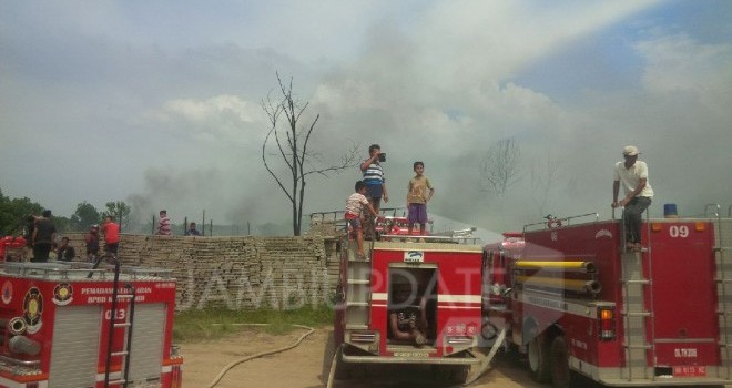 Terlihat petugas damkar berusaha memadamkan api yang membakar gudang minyak di Auduri. 