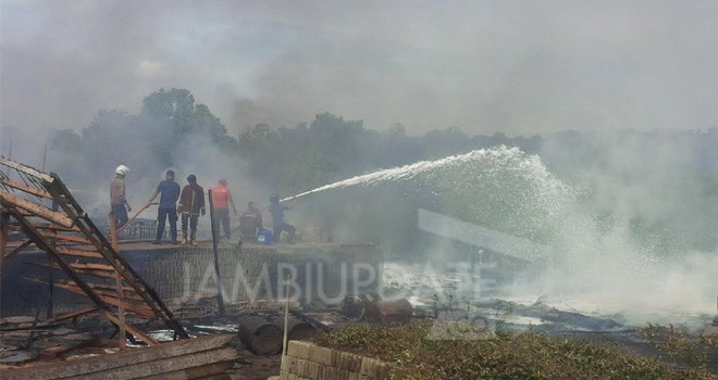 Petugas menggunakan deterjen untuk memadamkan api yang membakar gudang minyak di Auduri.