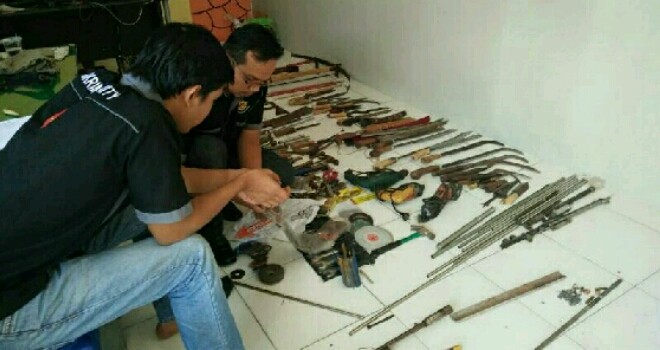 Terlihat polisi menggrebek gudang perakitan senjata di Merangin. 
