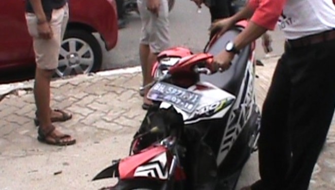 Tampak sepeda motor ringsek akibat menabrak mobil angkot.