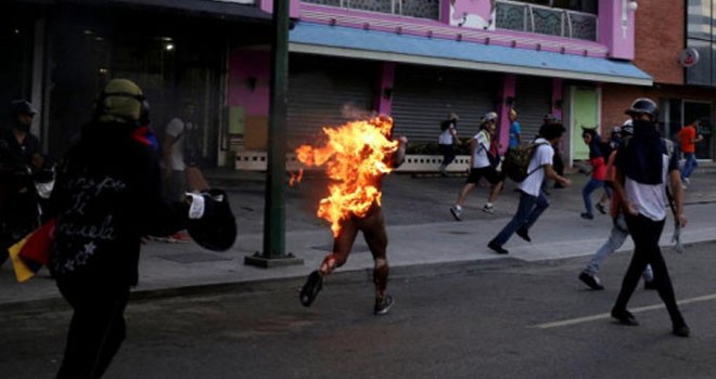 Seorang pria dibakar hidup-hidup karena ditudih mencuri di tengah demonstrasi menentang Presiden Nicolas Maduro. Foto: Marco Bello/Reuters