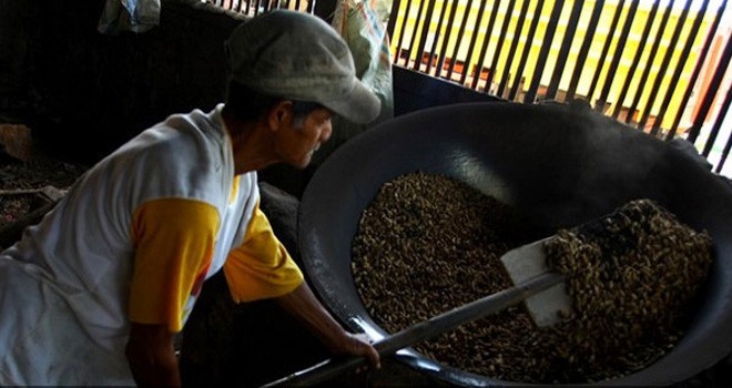 Pekerja saat menggoreng kacang tanah menggunakan pasir. Foto : JPNN.com