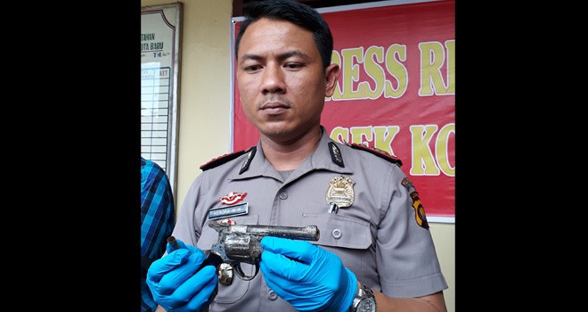Tampak polisi saat memperlihatkan senjata api yang ditemukan warga.