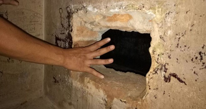 Petugas saat menunjukkan dinding kamar yang di lobang oleh para tahanan.