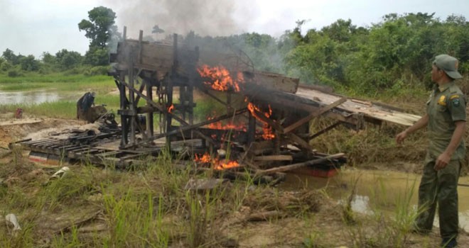 Petugas saat membakar mesin dompeng di kawasan PETI yang berlokasi di Dusun Sungai Buluh, Kecamatan Rimbo Tengah, Kabupaten Bungo, Selasa (15/8).