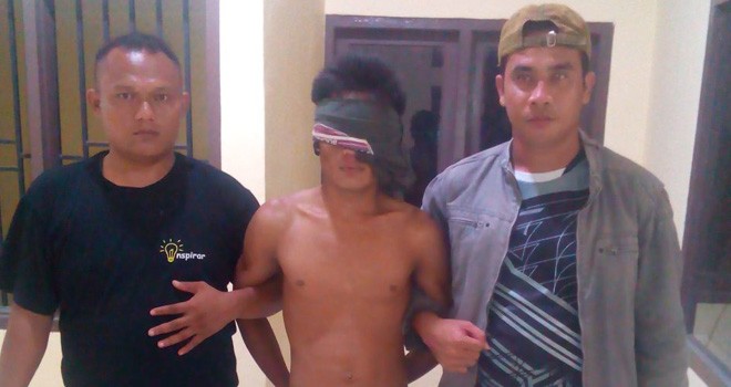 Tersangka Aziz (tengah) saat diamankan polisi di Kantor Polsek Muara Tabir, dini hari kemarin (24/8).