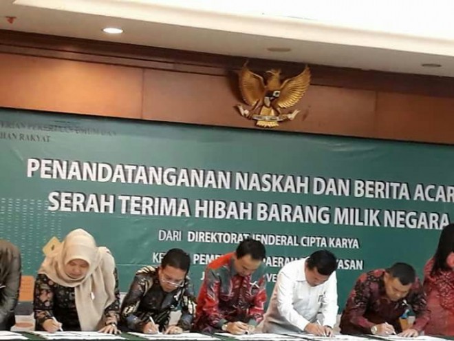 Bupati Masnah Busro saat menandatangani Naskah Serah Terima Hibah Barang dari Kementerian PUPR.