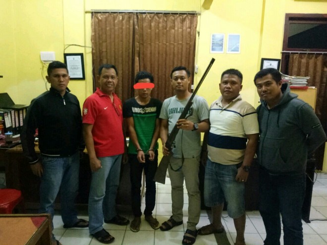 Tersangka Tandi saat diamankan bersama barang bukti. 