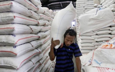 Ilustrasi seorang buruh panggul tengah mengangkut beras dari gudang penyimpanan (DOK.MIFTAHULHYAT/JAWA POS)