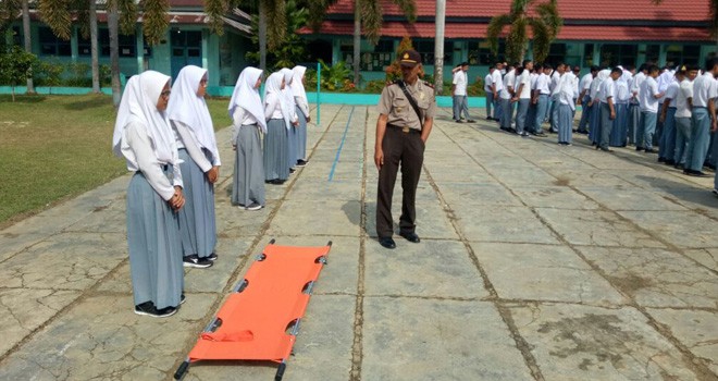 Salah satu anggota polisi saat menunjukkan lokasi dimana korban terjatuh pingsan.