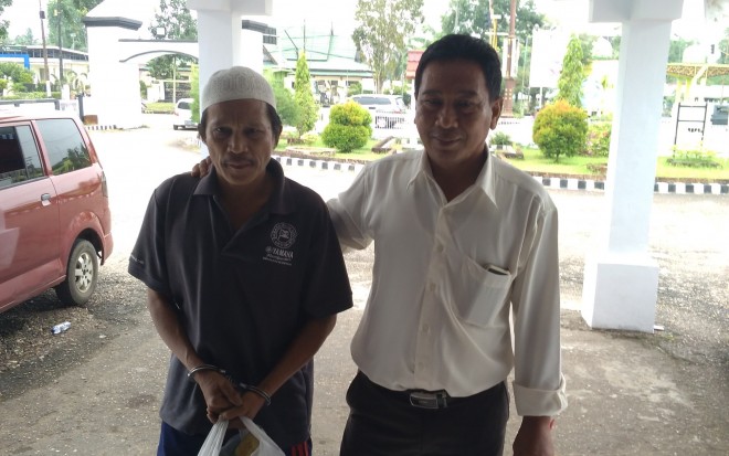 Tersangka terosman (54) terlihat diiringi oleh pihak kepolisian.