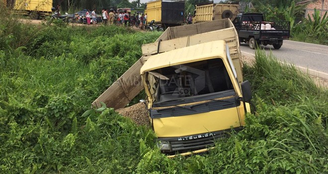 Truk bermuatan krikil nyungsep di pinggir jalan usai bertabrakan dengan truk pembawa batu bara di RT02 Desa Serasah, Kecamatan Pemayung, Kabupaten Batanghari, Senin (19/2).