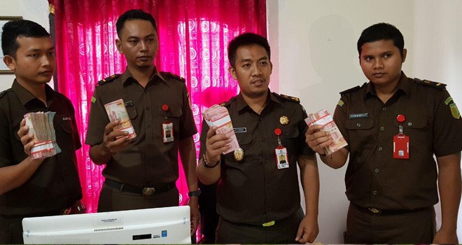 Jaksa Kejari Muara Tebo saat memperlihatkan uang yang dikembalikan oleh keluarga Busman, Selasa (3/4).